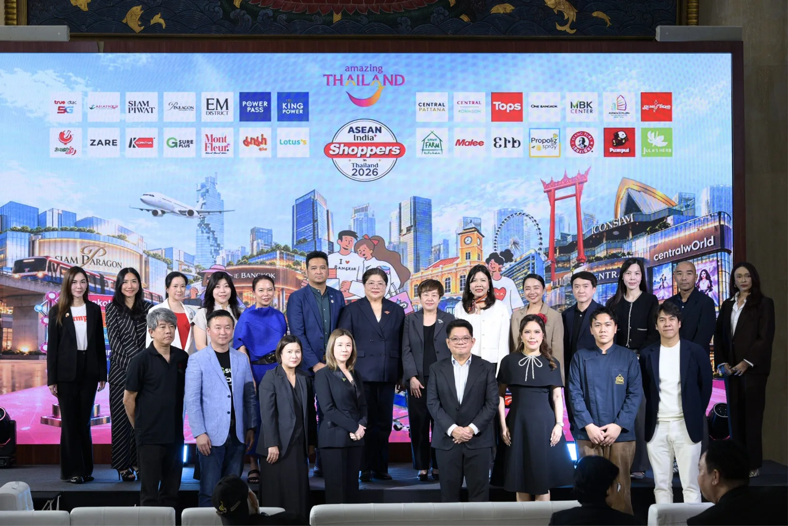 ผู้บริหาร ททท. และตัวแทนพาร์ตเนอร์ค้าปลีกถ่ายภาพร่วมกันบนเวทีหน้าฉากโลโก้พาร์ตเนอร์ของโครงการ