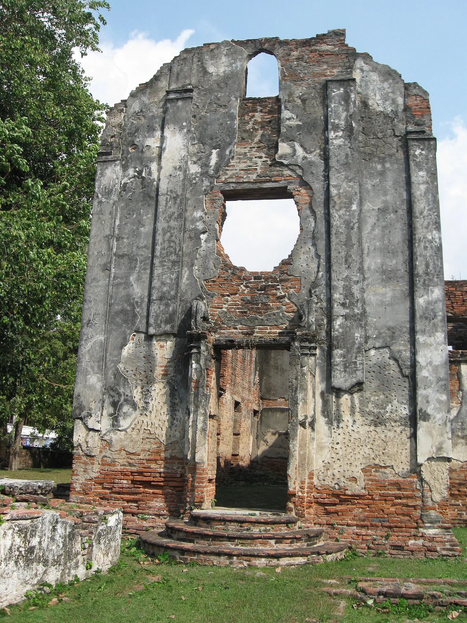 ผนังสูงที่มีช่องหน้าต่างวงกลมด้านบน ในบ้านวิชาเยนทร์
