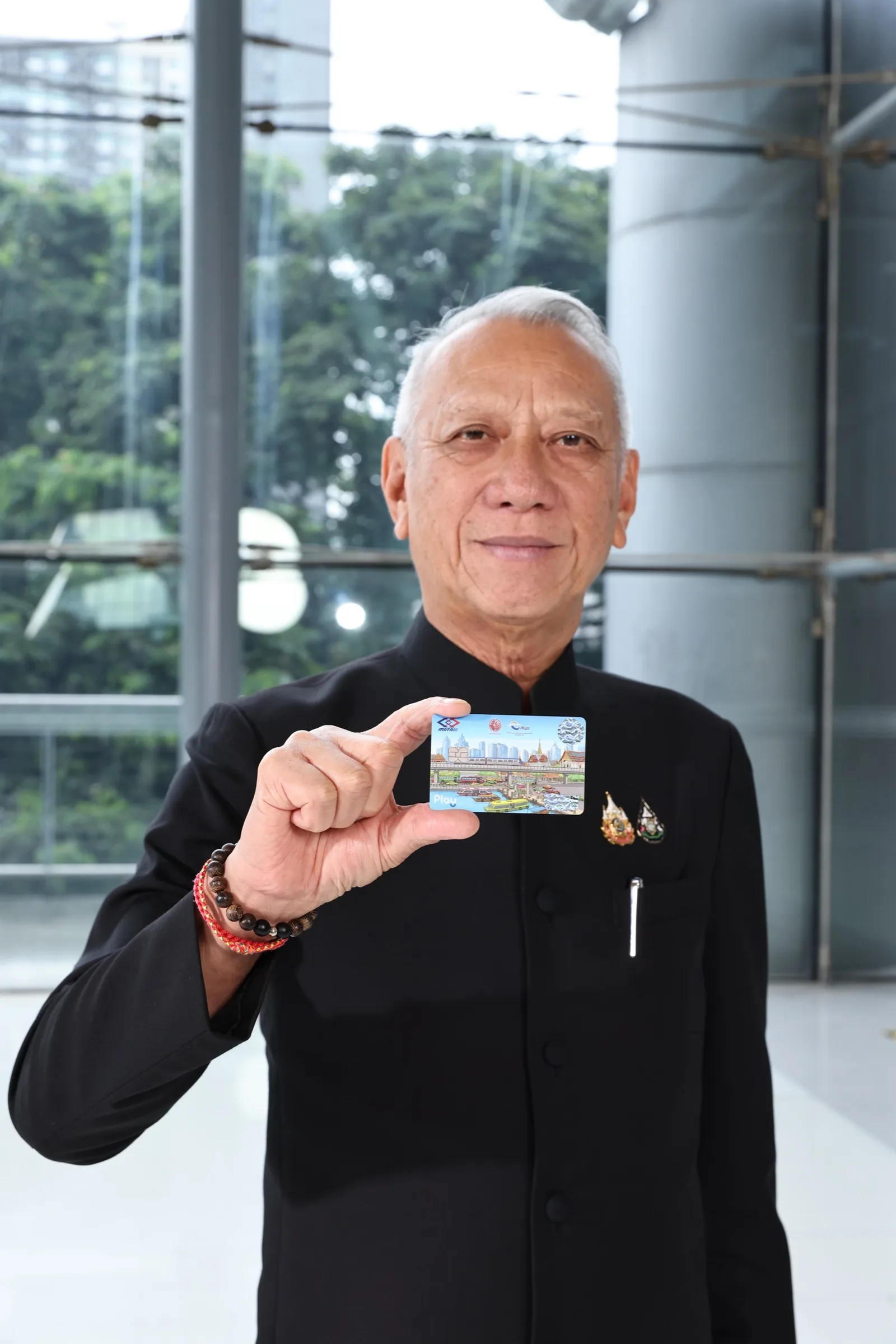 นายพิพัฒน์ รัชกิจประการ ชูบัตรในมือ ในภาพที่รัฐบาลเผยแพร่พร้อมข่าวแผนตั๋วร่วมรถไฟฟ้า 17–45 บาท 10 ตุลาคม 2026