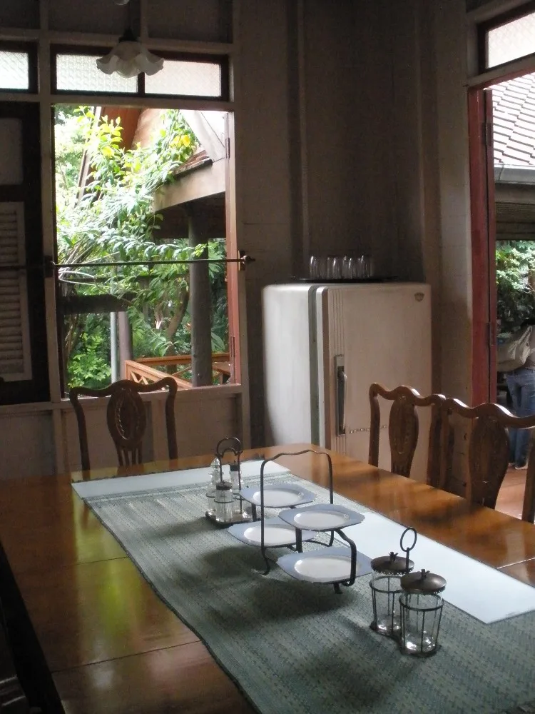 ห้องอาหารในพิพิธภัณฑ์ชาวบางกอก โต๊ะไม้ยาวกับเก้าอี้ ข้างหน้าต่างไม้