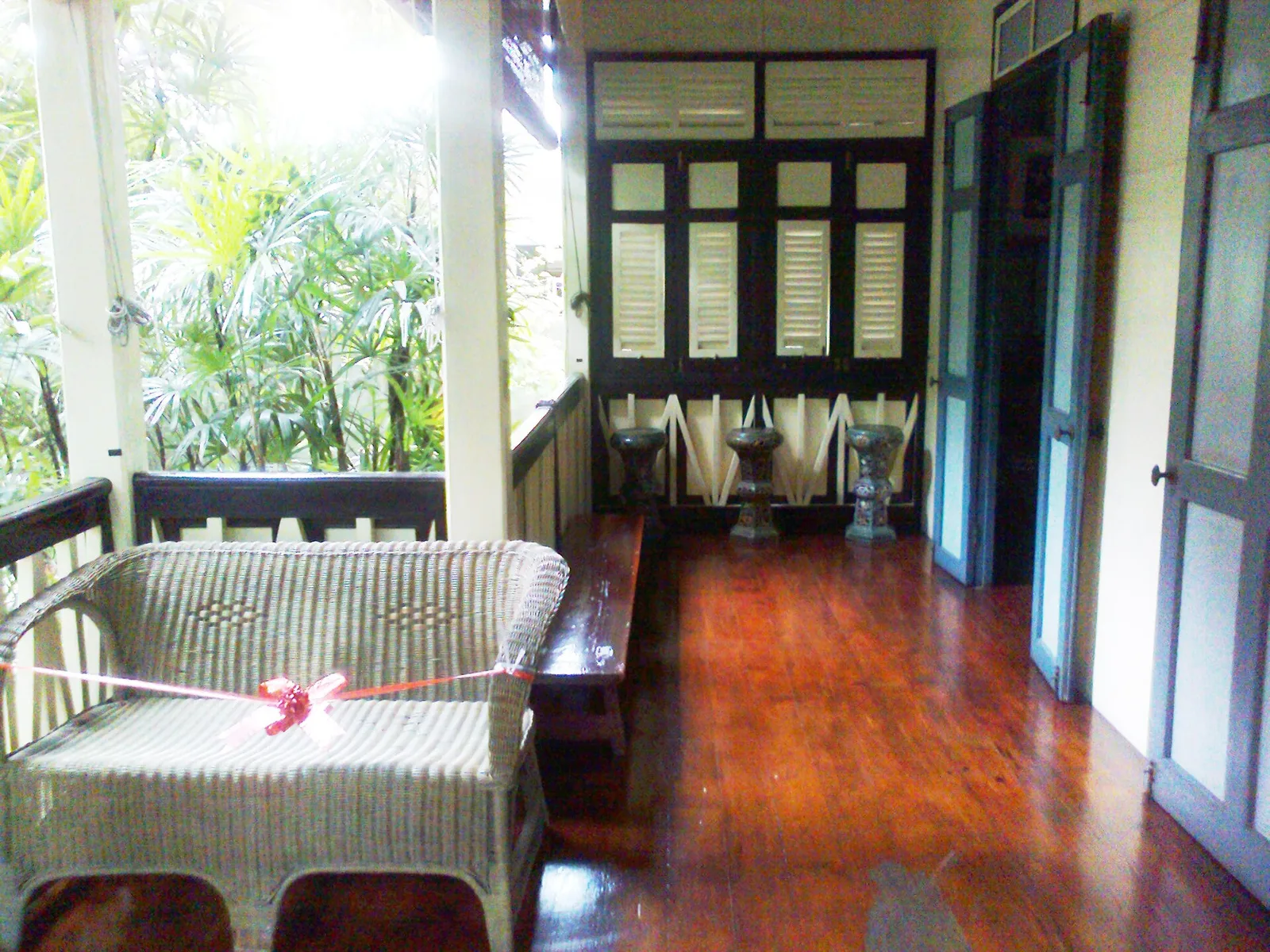 ระเบียงในเรือนไม้ของพิพิธภัณฑ์ชาวบางกอก มีเก้าอี้หวายและโต๊ะ