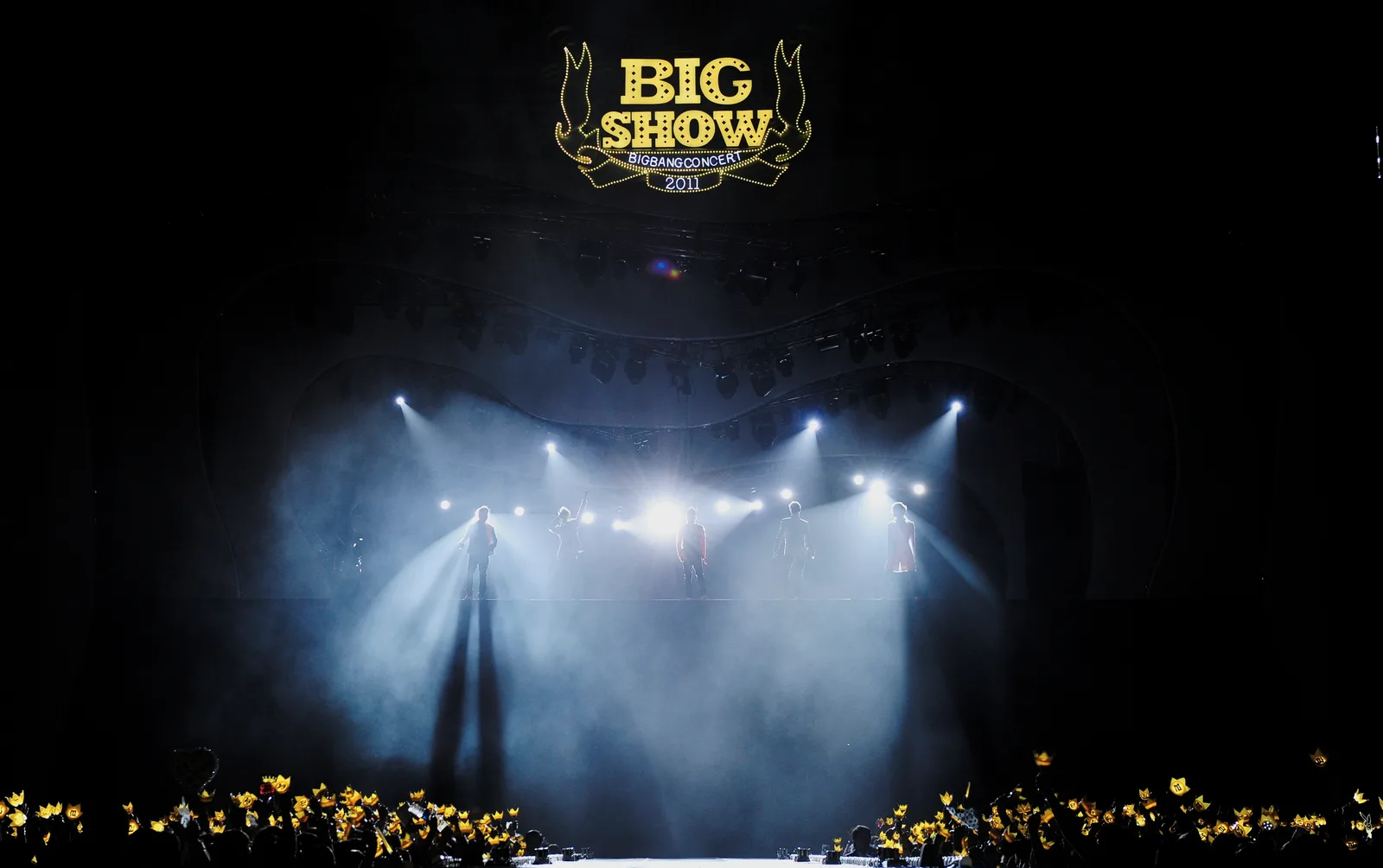 BIGBANG บนเวทีคอนเสิร์ต Big Show ปี 2011 แฟนเพลงชูแท่งไฟมงกุฎสีเหลือง วงที่จะมาคอนเสิร์ต BIGBANG ราชมังคลา 7–8 พ.ย. 2569