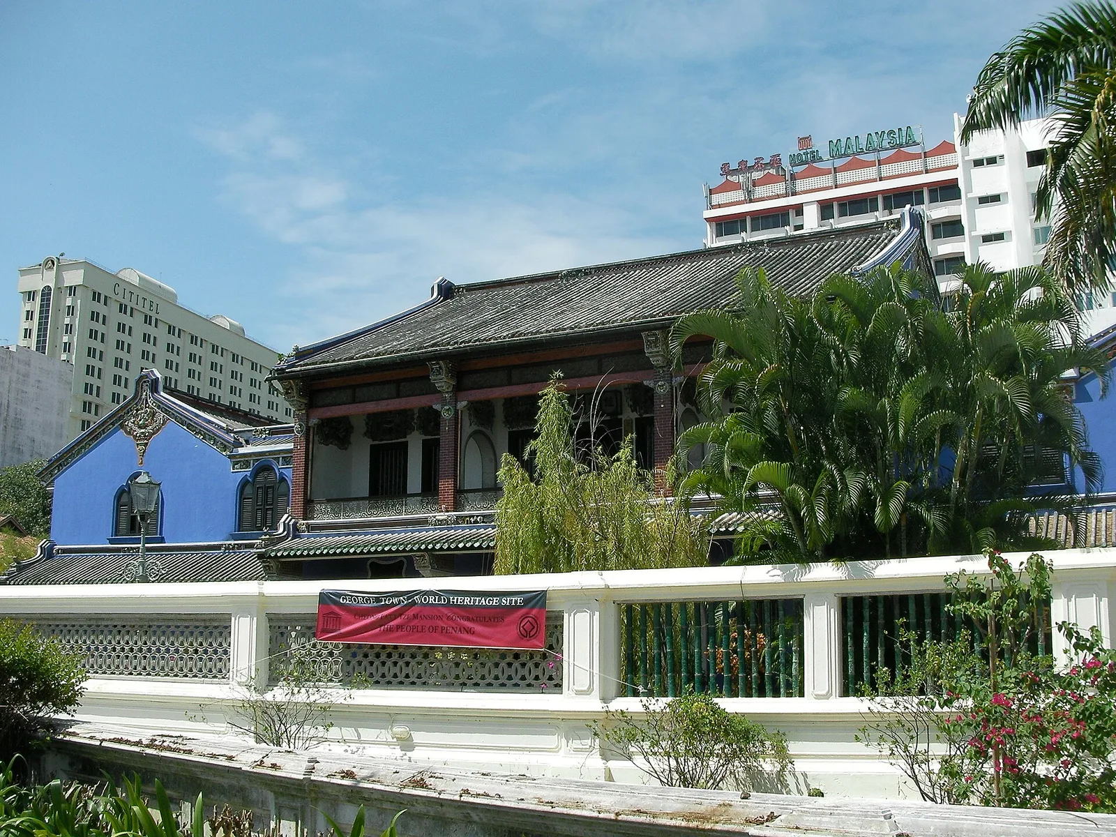 คฤหาสน์ Cheong Fatt Tze มองจากนอกกำแพง เห็นหลังคากระเบื้องแบบจีนและต้นไม้ ภาพถ่ายเดือนธันวาคม 2008