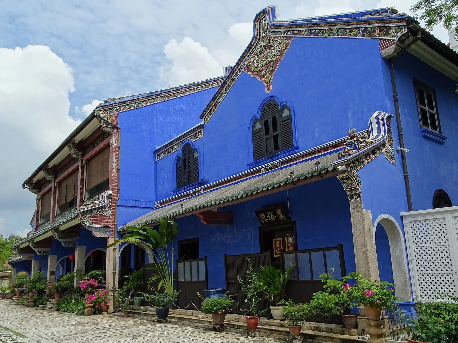 ด้านข้างคฤหาสน์ Cheong Fatt Tze หลังคากระเบื้องและไม้กระถางเรียงตามระเบียง ภาพถ่ายเดือนมิถุนายน 2017