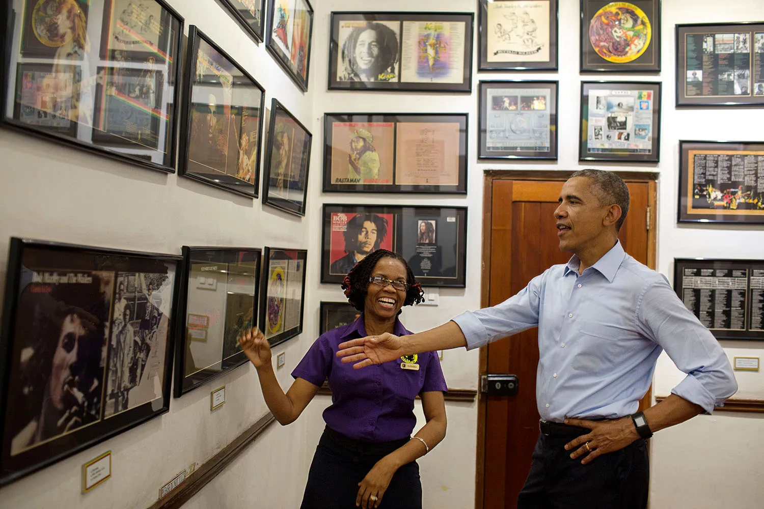 ประธานาธิบดี Barack Obama ชมของที่ระลึกในกรอบบนผนังกับไกด์ของ Bob Marley Museum เมื่อ 8 เมษายน 2015 ภาพถ่ายทางการของทำเนียบขาว