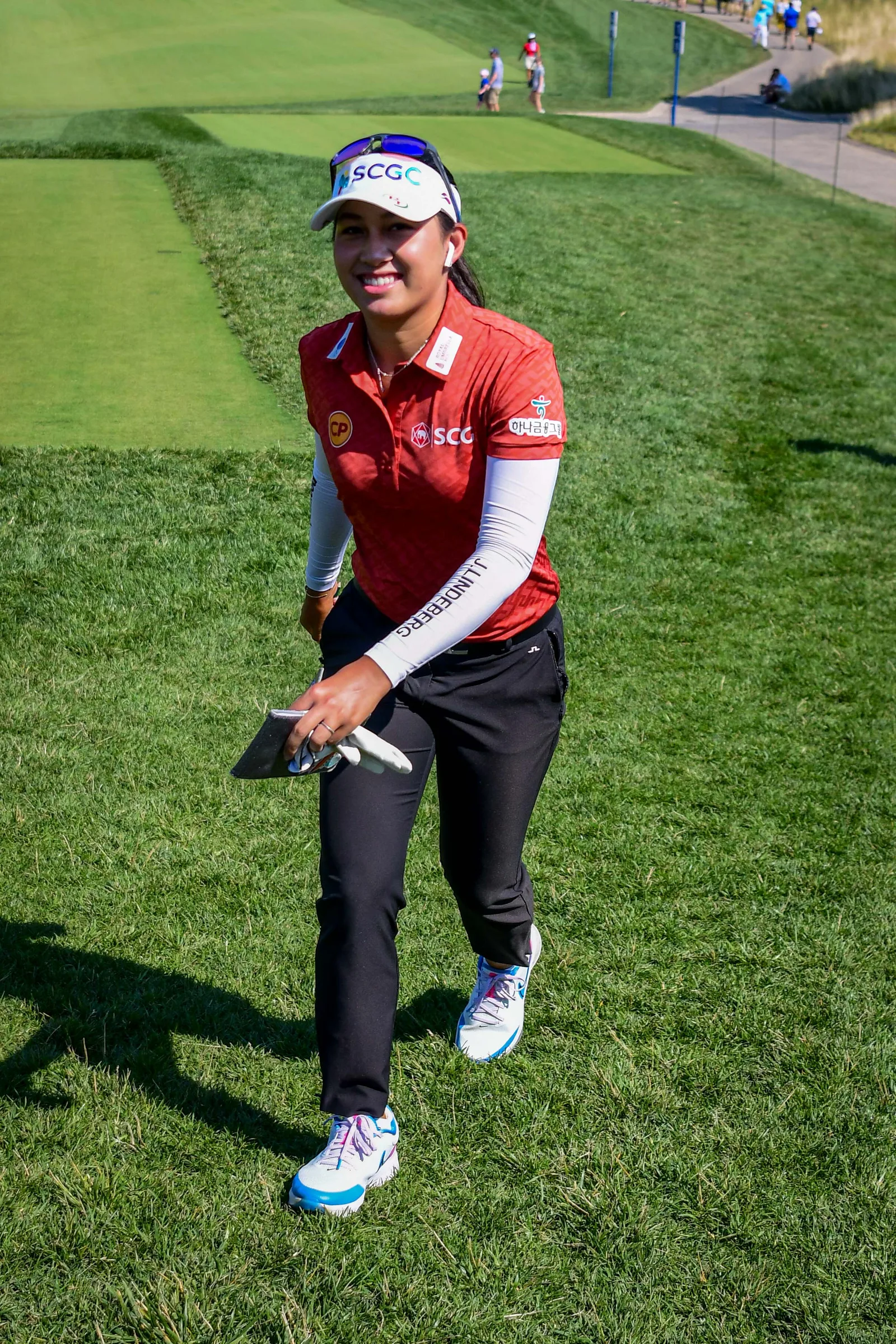 จีโน่ อาฒยา ฐิติกุล แชมป์เก่า Buick LPGA Shanghai 2026 ในชุดแข่งเสื้อโปโลสีแดง หมวกแก๊ปและรองเท้ากอล์ฟ เดินบนแฟร์เวย์ในรอบสุดท้าย KPMG Women's PGA Championship เมื่อ 26 มิถุนายน 2022