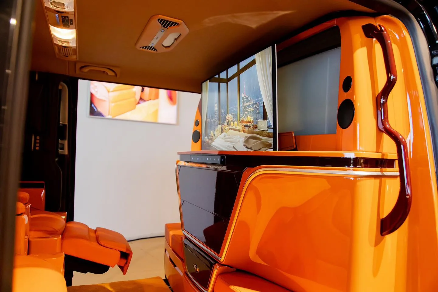ห้องโดยสาร Volkswagen THAIYARNYON Caravelle Comfortline NGZ โทนสีส้ม มี Partition จอทีวี ลำโพง และเบาะ VIP ที่ยกที่รองน่อง
