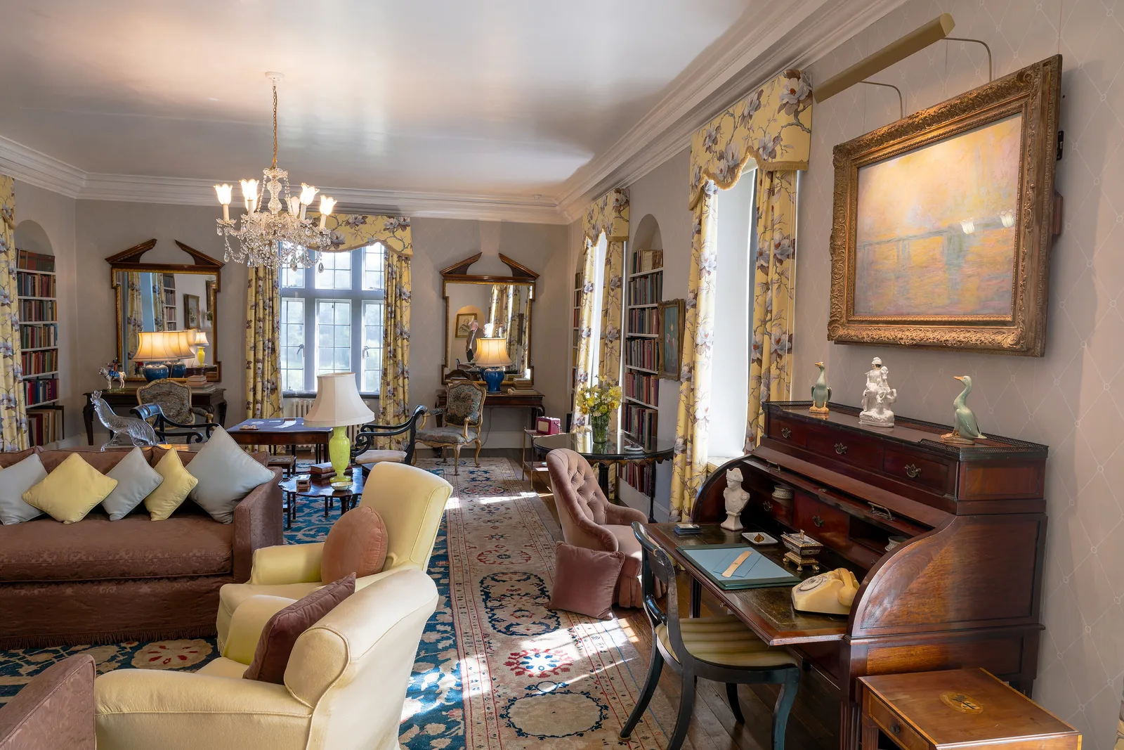 ห้องรับแขก (Drawing Room) ของบ้าน Chartwell มีโซฟา โคมระย้า และชั้นหนังสือ ภาพถ่ายเมื่อ 8 กันยายน 2025