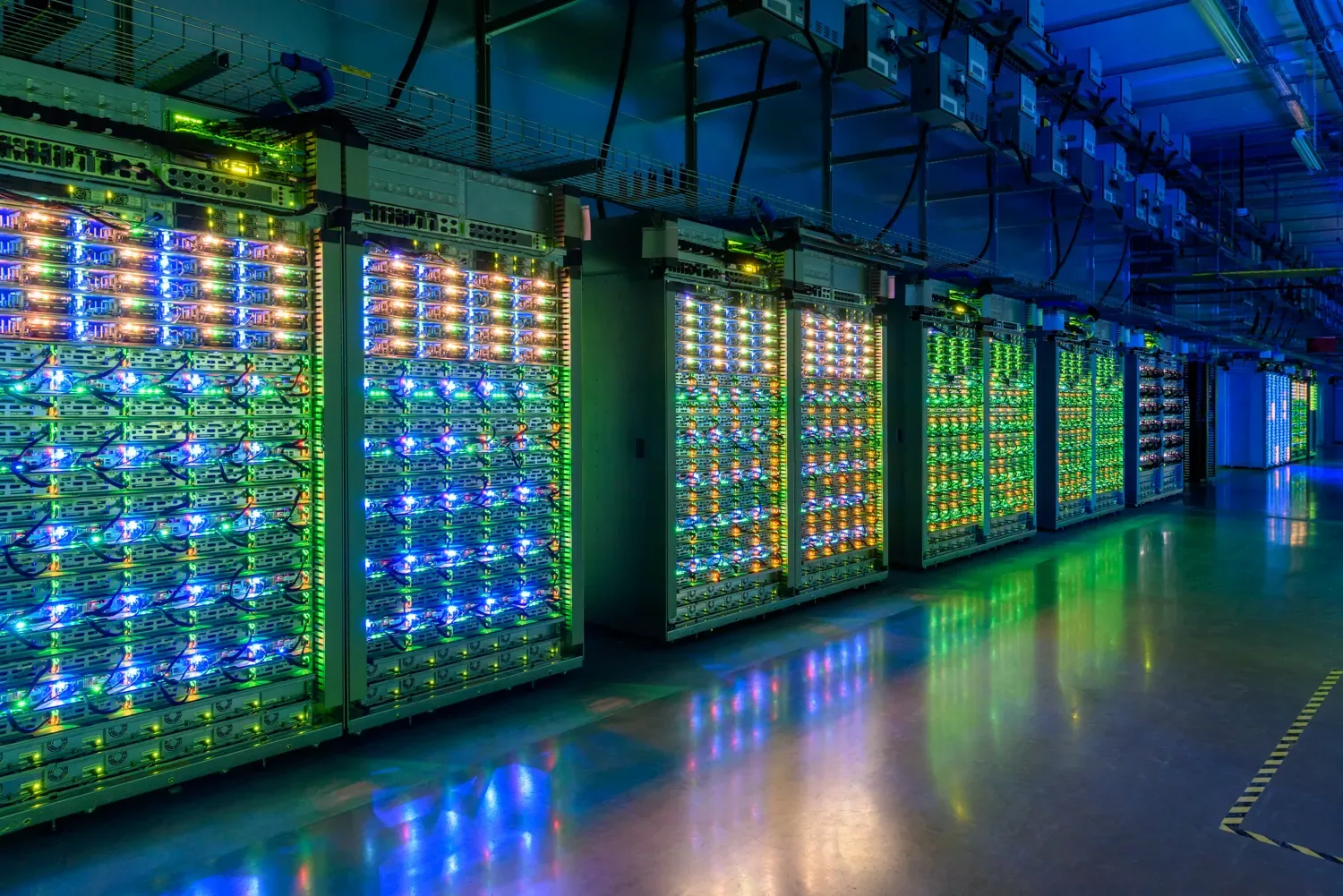แถวเซิร์ฟเวอร์ไฟสีเขียวและน้ำเงินภายในศูนย์ข้อมูล St. Ghislain ของ Google ภาพประกอบเรื่องส่วนลดผูกสัญญาคลาวด์