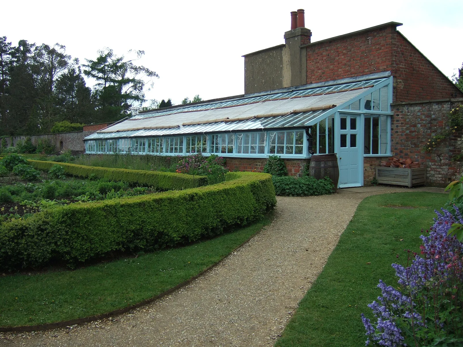 สวนครัวของบ้าน Charles Darwin มีโรงเรือน ถังเก็บน้ำ แนวพุ่มไม้ และแปลงผัก ภาพถ่ายเมื่อ 2 พฤษภาคม 2014