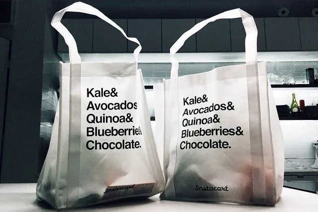 ถุงผ้าส่งของชำของ Instacart สองใบวางบนเคาน์เตอร์ ภาพถ่ายปี 2015