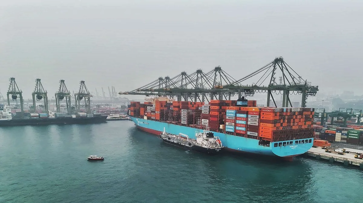 Ethanol Bunkering สิงคโปร์: เรือคอนเทนเนอร์ Maersk Halifax เทียบท่า Pasir Panjang ใต้ปั้นจั่นยกตู้ มีเรือบรรทุกเชื้อเพลิงขนาดเล็กเทียบข้างลำ