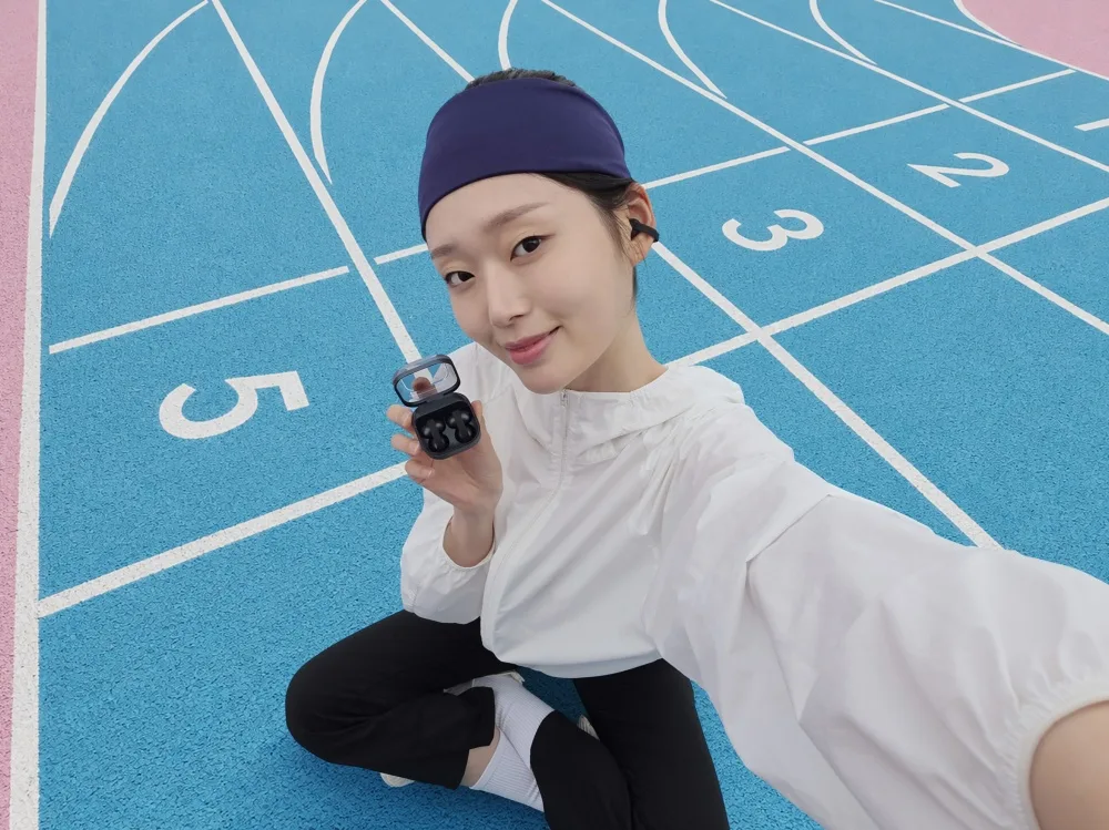 ผู้ใช้สวม Galaxy Buds On บนลู่วิ่งและถือเคสชาร์จ ภาพประชาสัมพันธ์การวางขายในเกาหลีใต้