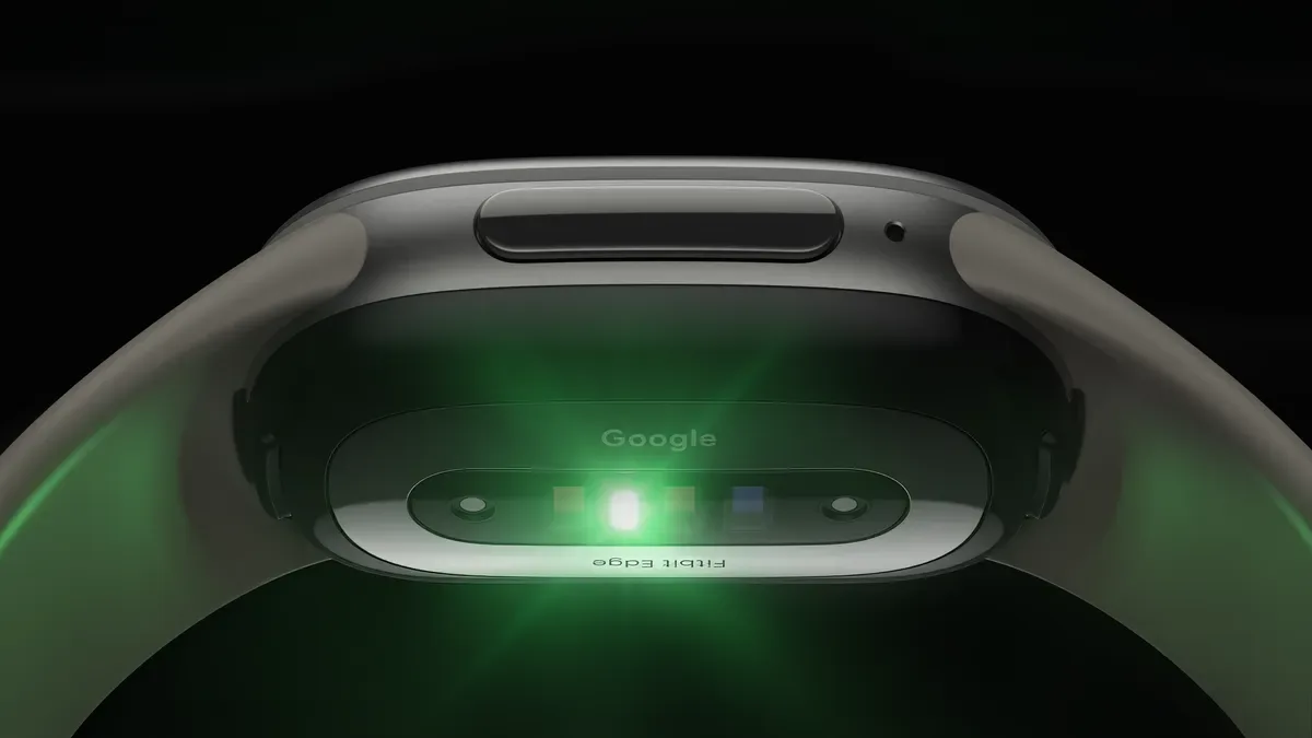 ด้านล่างของ Fitbit Edge แสดงชุดเซนเซอร์สุขภาพที่เปล่งแสงสีเขียว