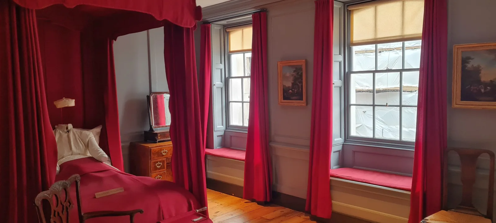 ห้องที่มีเตียงและม่านสีแดงภายใน 25 Brook Street ภาพถ่ายเมื่อ 23 มีนาคม 2025