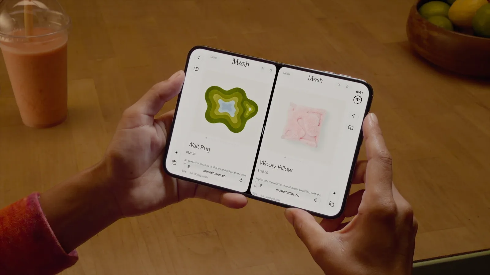 มือสองข้างถือ iPhone Duo แบบกางแนวนอน จอด้านในเปิดหน้าเว็บร้านค้าสองหน้าต่างคู่กันด้วย Split View