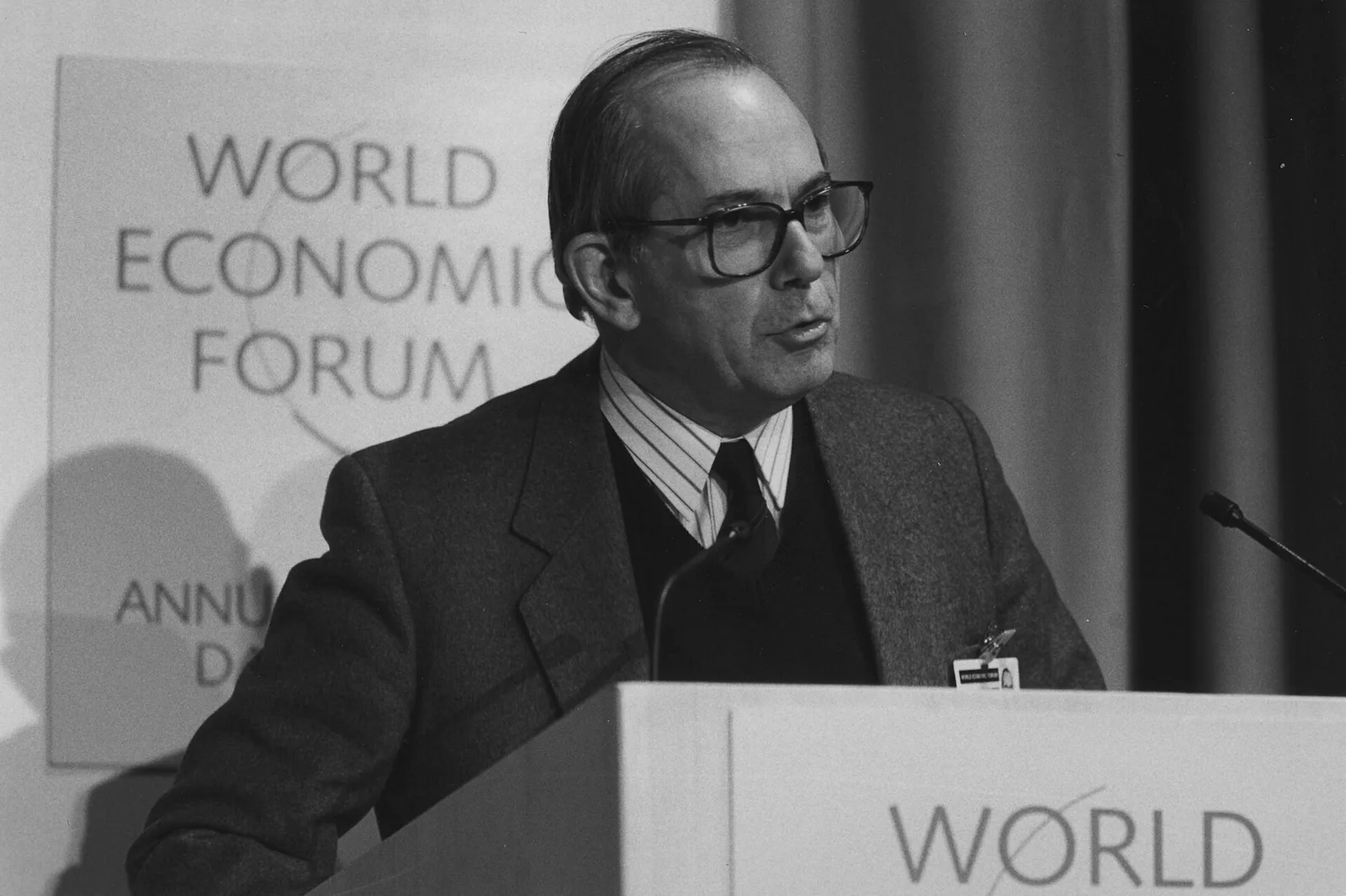 ภาพขาวดำ Michel Camdessus กรรมการผู้จัดการ IMF กล่าวบนโพเดียม World Economic Forum ที่ดาวอส มกราคม 1989