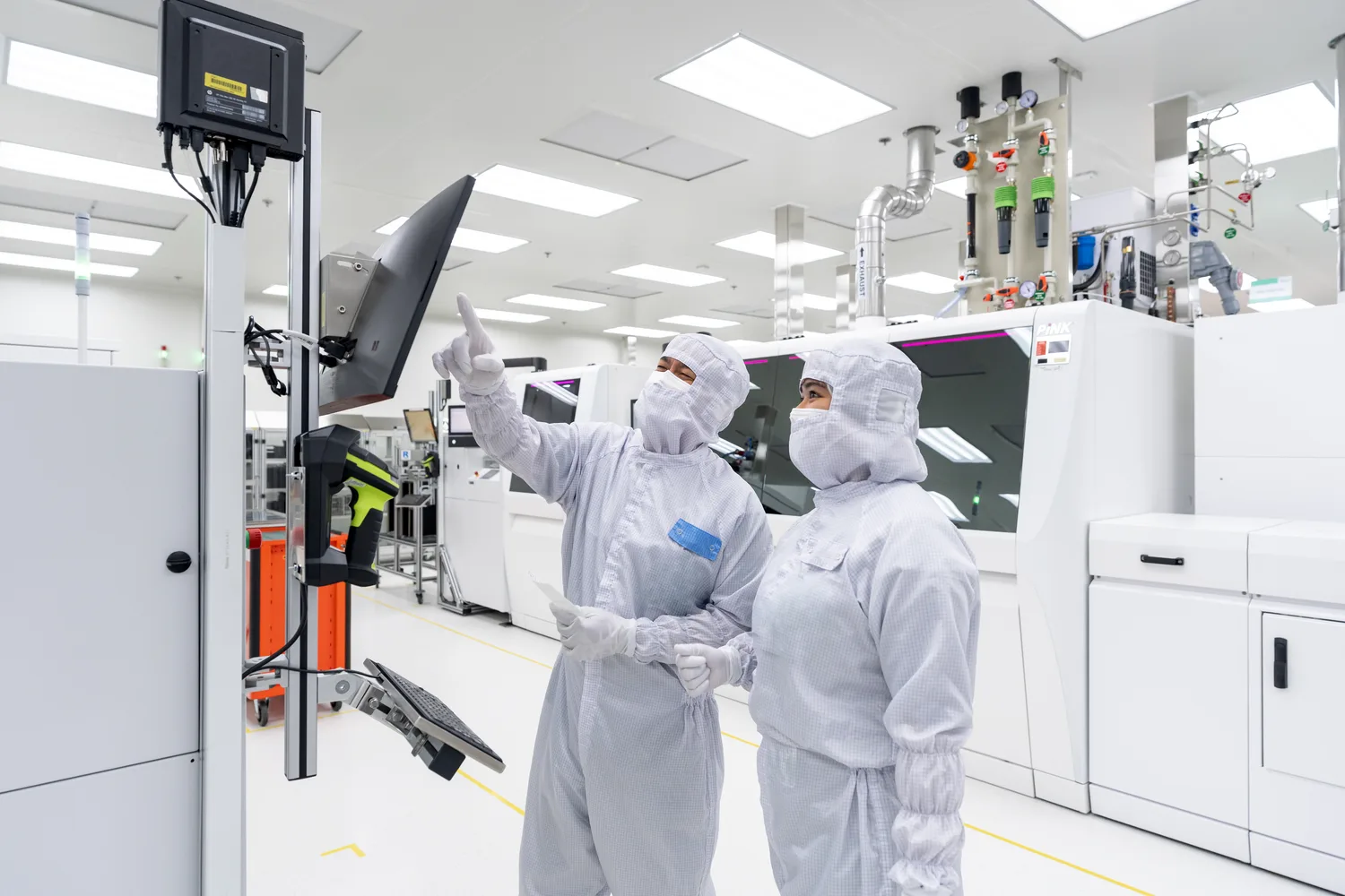 พนักงานในชุดคลีนรูมทำงานกับเครื่องจักรภายในโรงงาน Infineon ที่สมุทรปราการ