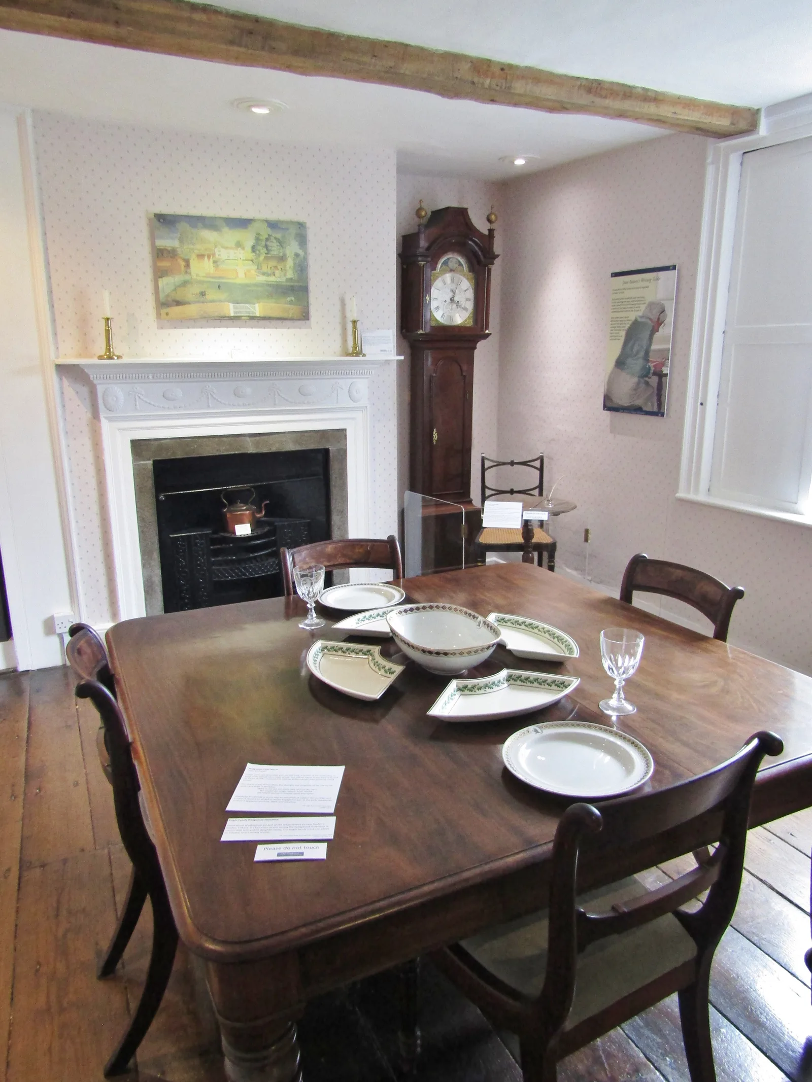 ห้องภายในบ้านของ Jane Austen ที่จัดโต๊ะอาหาร เตาผิง และนาฬิกาตั้งพื้น ภาพถ่ายเมื่อ 14 สิงหาคม 2019