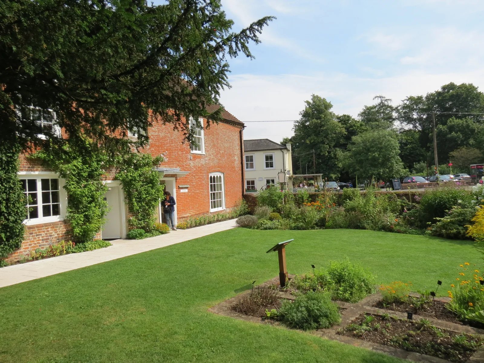 สนามหญ้าและแปลงไม้ดอกข้างบ้านของ Jane Austen ใน Chawton ภาพถ่ายเมื่อ 1 กันยายน 2012