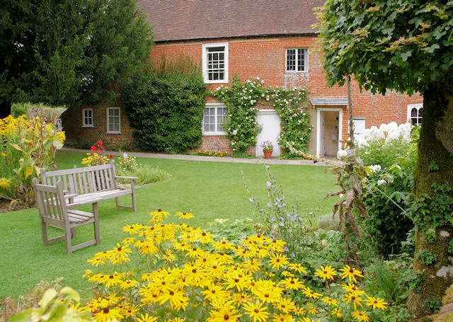 ม้านั่งและแปลงดอกไม้ในสวนบ้านของ Jane Austen ภาพถ่ายเมื่อ 29 สิงหาคม 2008