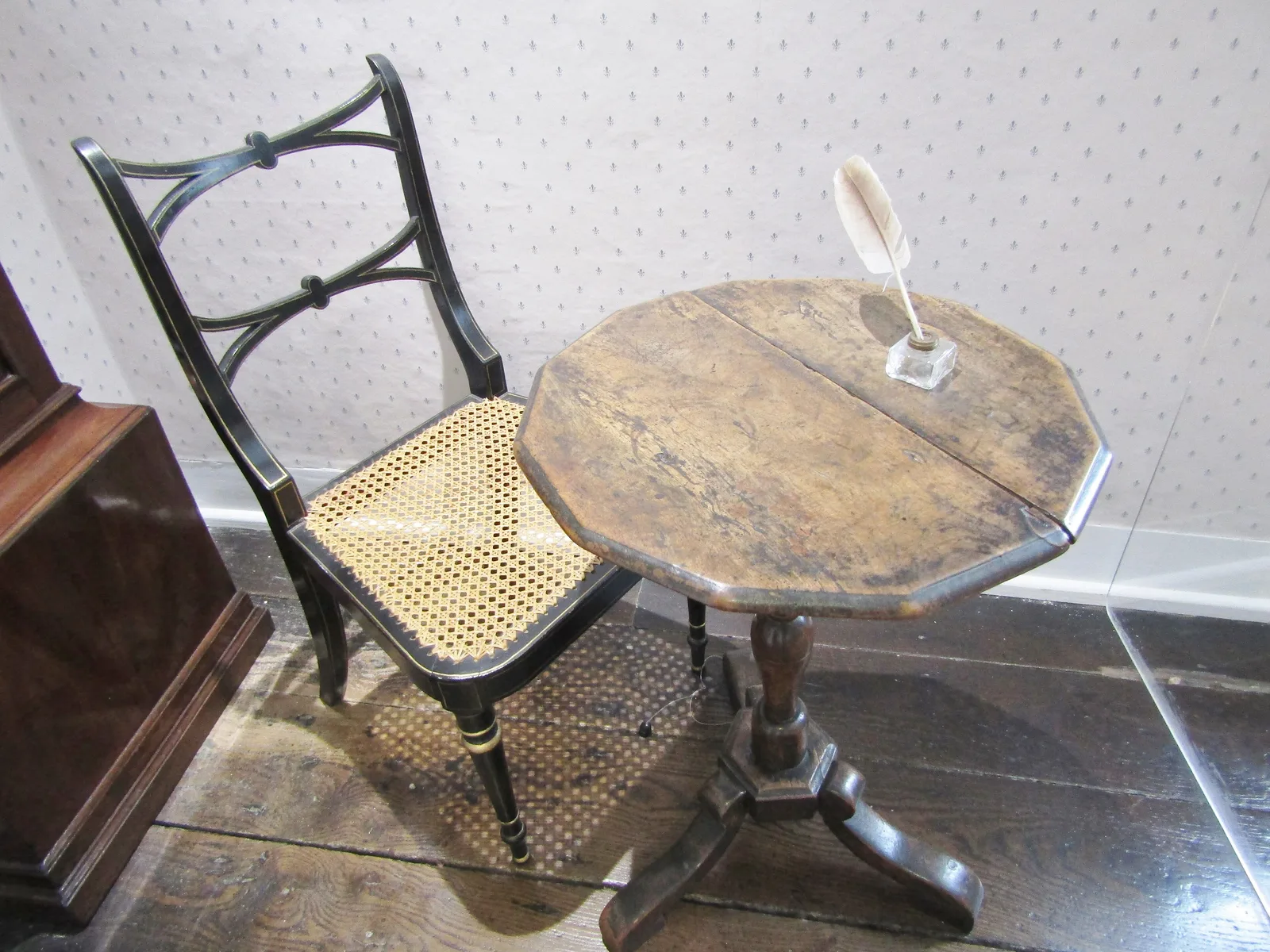 โต๊ะกลมขนาดเล็กกับเก้าอี้ในตู้กระจกภายในบ้านของ Jane Austen ภาพถ่ายเมื่อ 14 สิงหาคม 2019
