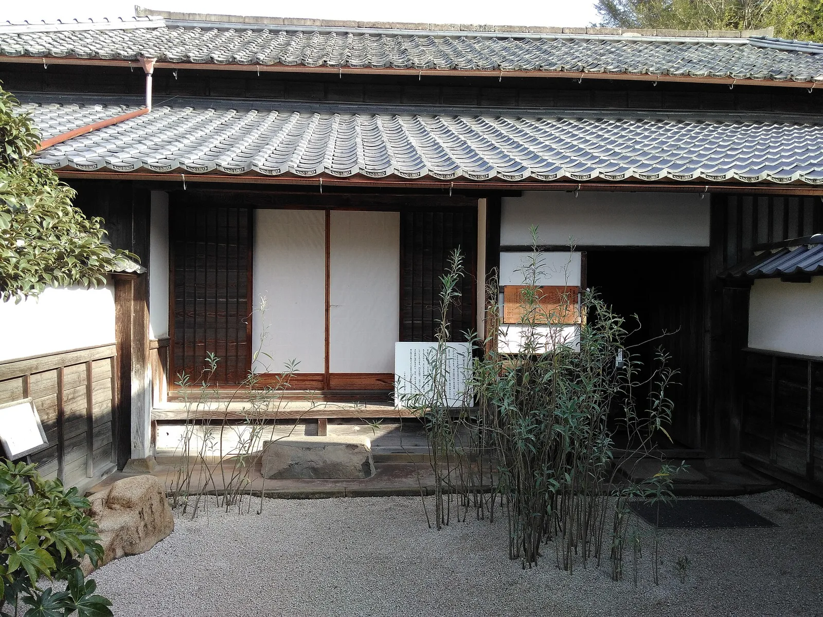 ลานทางเข้าบ้านพักเดิมของ Lafcadio Hearn พื้นกรวด ประตูเลื่อนกระดาษ และหลังคากระเบื้อง ภาพถ่ายเดือนตุลาคม 2016