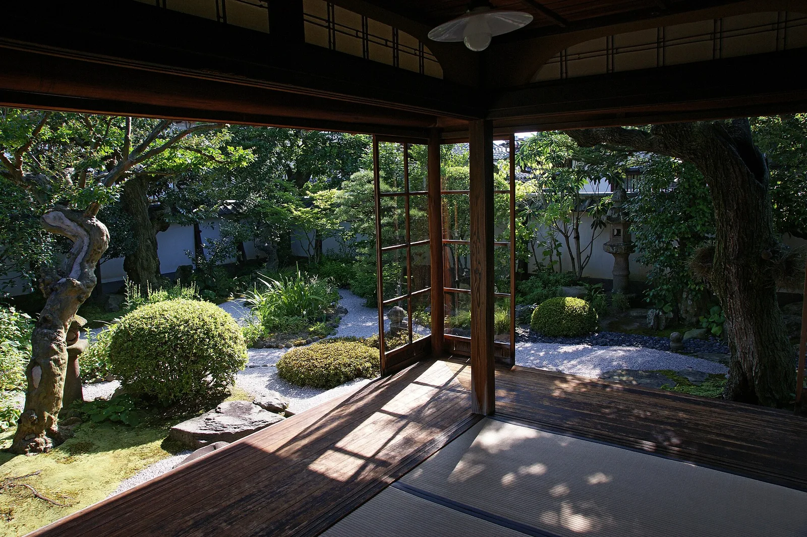 ห้องตาตามิในบ้านพักเดิมของ Lafcadio Hearn เปิดประตูเลื่อนสองด้าน เห็นสวนต้นไม้ตัดแต่งและแนวไม้พุ่ม ภาพถ่ายเดือนกรกฎาคม 2008