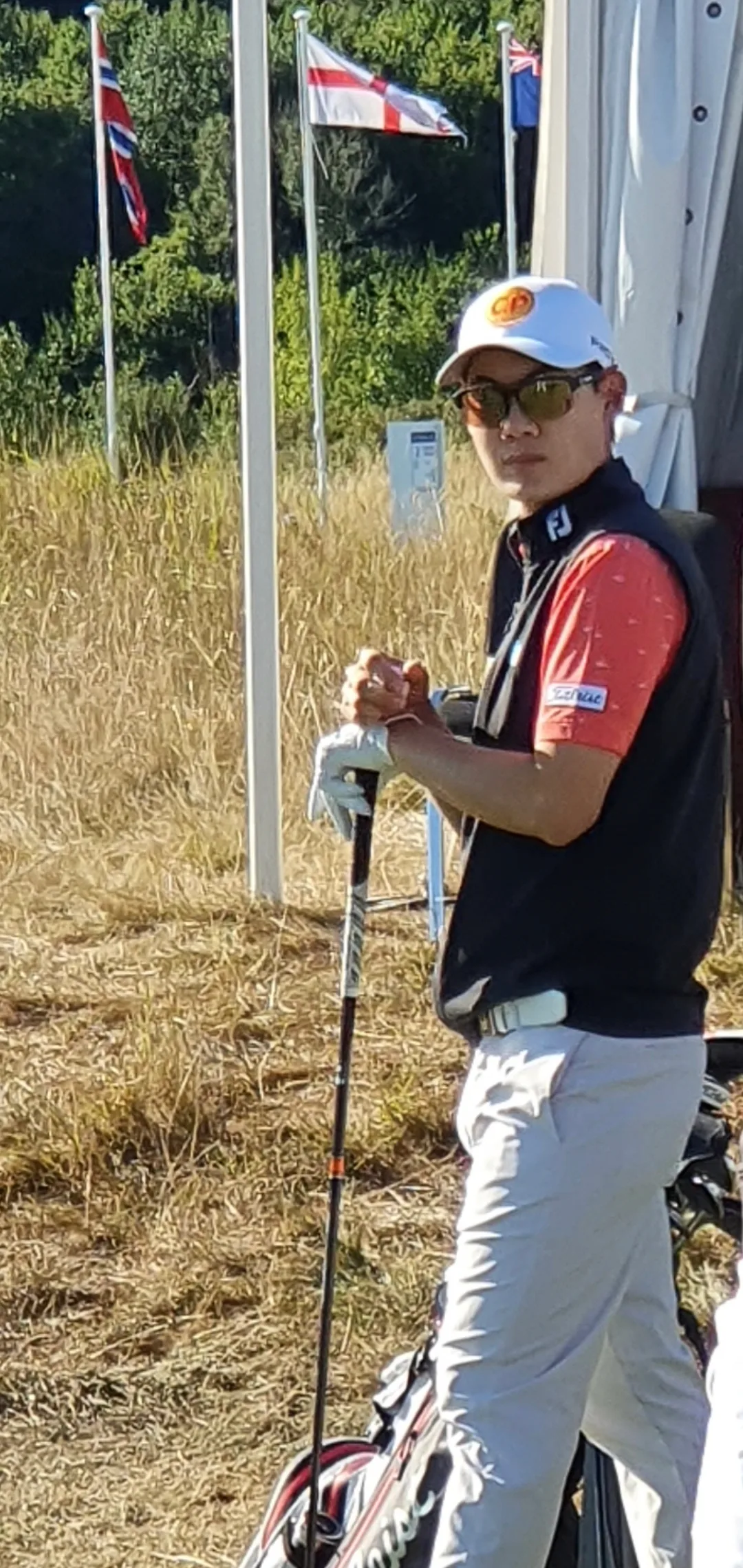 Jazz Janewattananond นักกอล์ฟไทยที่ตามผู้นำ 1 สโตรกใน Link Hong Kong Open 2026 รอบแรก สวมหมวกแก๊ป แว่นกันแดด ถุงมือ และถือไม้กอล์ฟ ภาพปี 2022