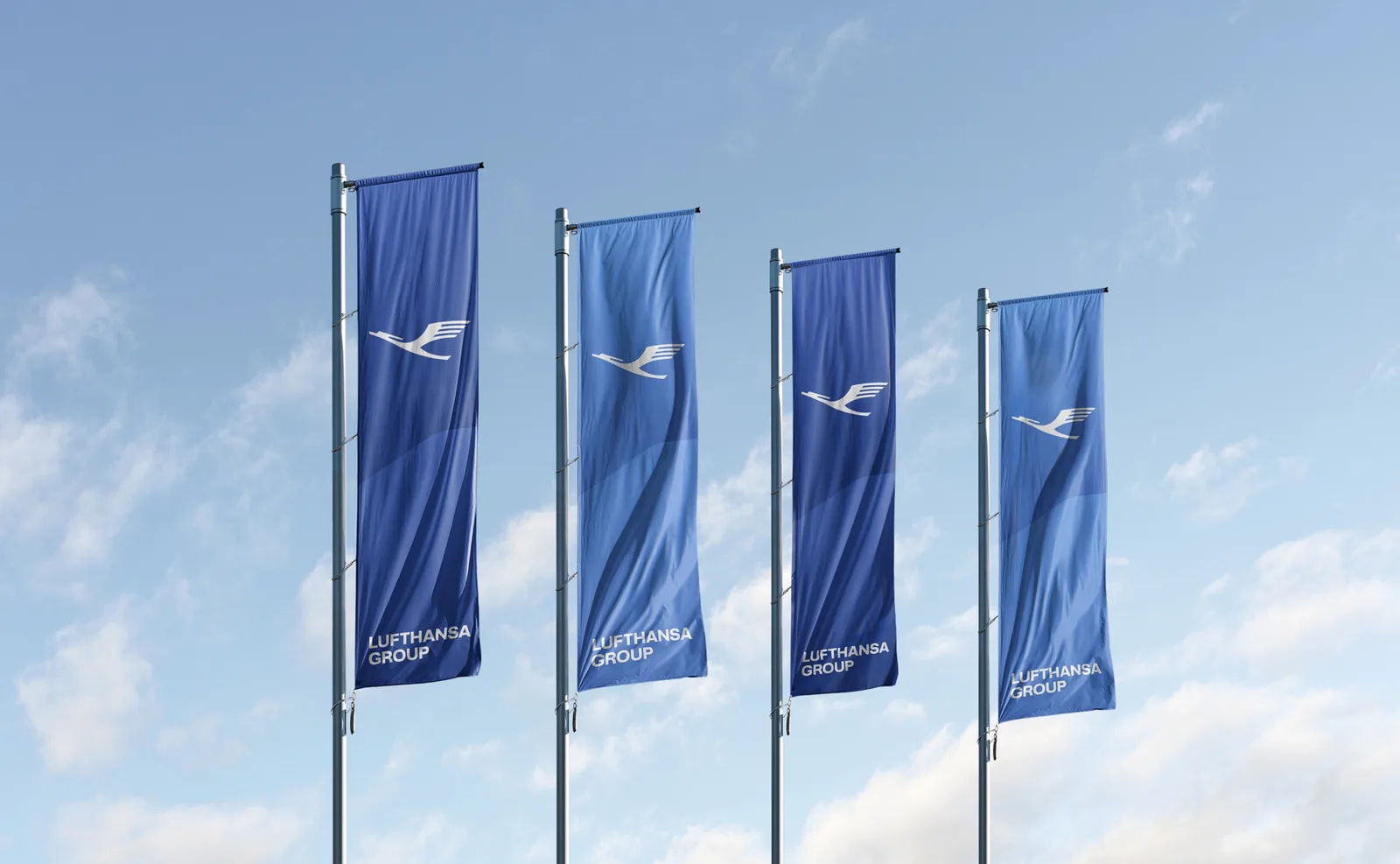 ธงของ Lufthansa Group สี่ผืนบนเสาธง ภาพประกอบประกาศของ Lufthansa Group เรื่องดีล Lufthansa TAP