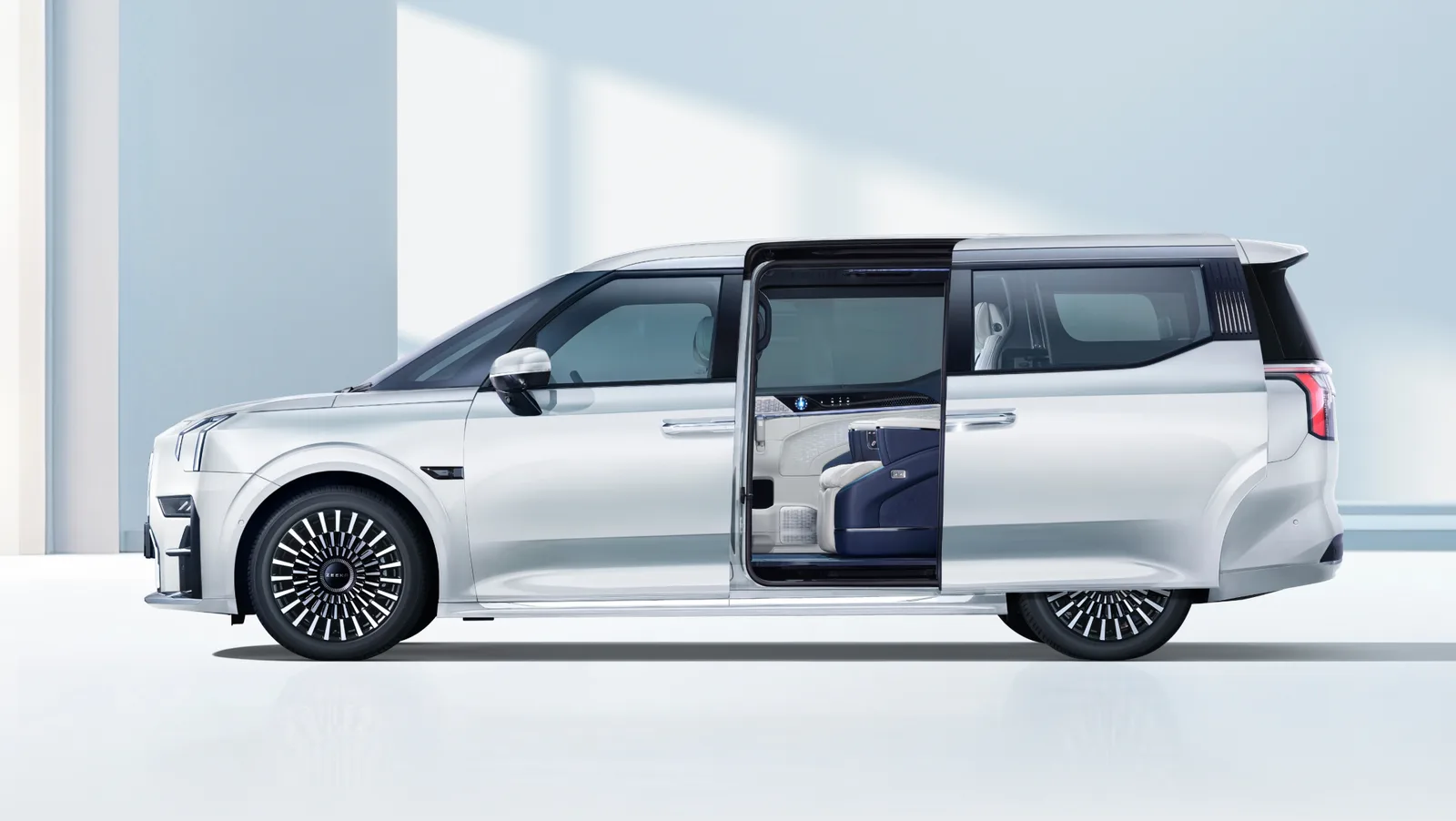 ZEEKR 009 สีขาว มุมด้านข้าง เปิดประตูสไลด์ให้เห็นเบาะแถวสองแบบแยกที่นั่ง