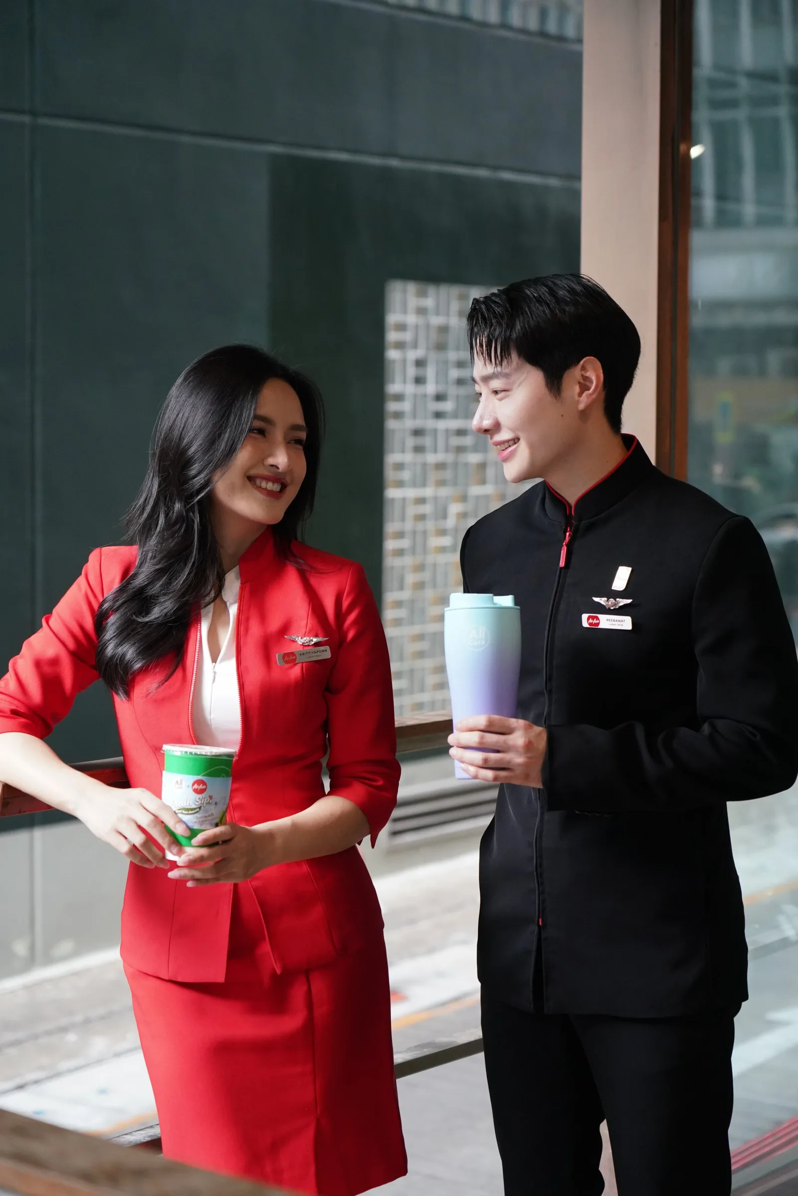 ลูกเรือแอร์เอเชียสองคนถือเครื่องดื่ม All Café และแก้ว Tumbler รุ่นพิเศษ