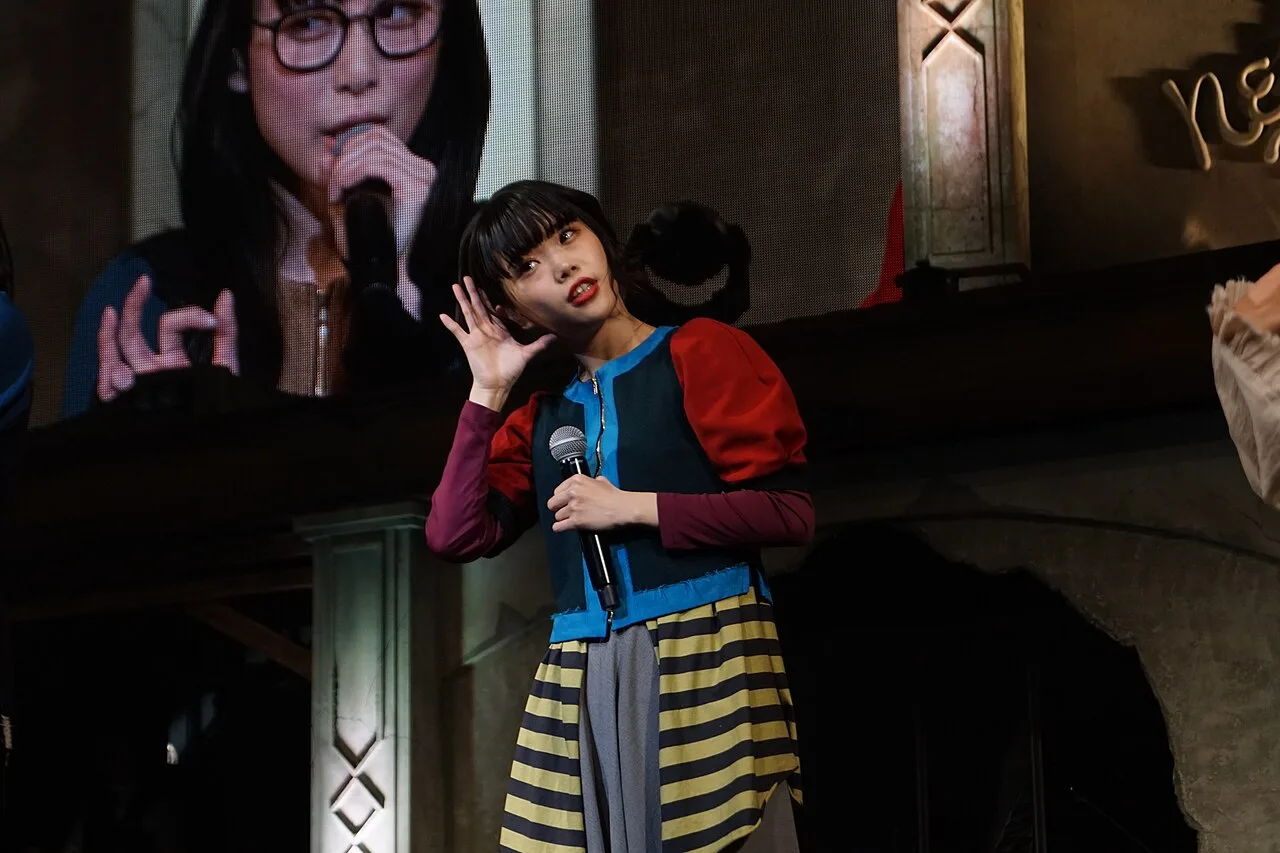 AiNA THE END ถือไมโครโฟนบนเวทีระหว่างการแสดงกับวง BiSH ปี 2019