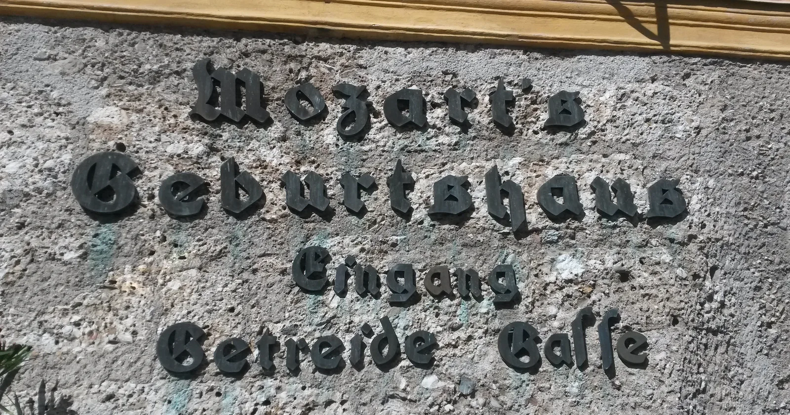 ป้ายหินเขียนว่า Mozarts Geburtshaus Eingang Getreide Gasse ภาพถ่ายเมื่อ 3 สิงหาคม 2015
