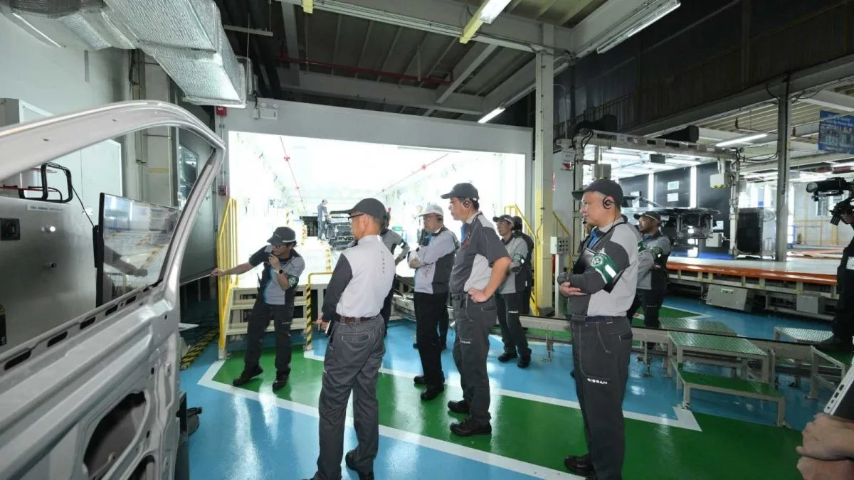 ผู้บริหารและพนักงานยืนดูสายการผลิตข้างตัวถังรถกระบะในโรงงาน Nissan จังหวัดสมุทรปราการ