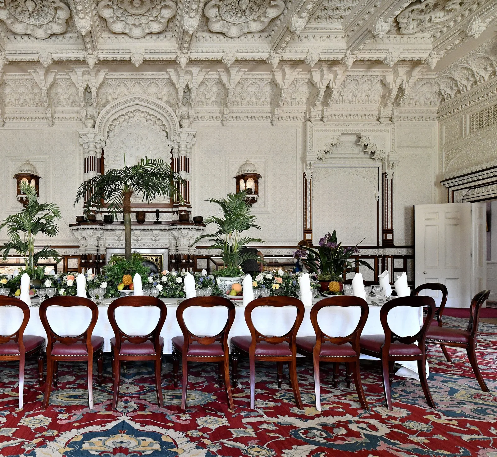 Durbar Room ของ Osborne House เพดานและผนังปูนปั้นสีขาวลายอินเดีย โต๊ะจัดเลี้ยงยาวและเก้าอี้ไม้ ภาพถ่ายเดือนสิงหาคม 2019