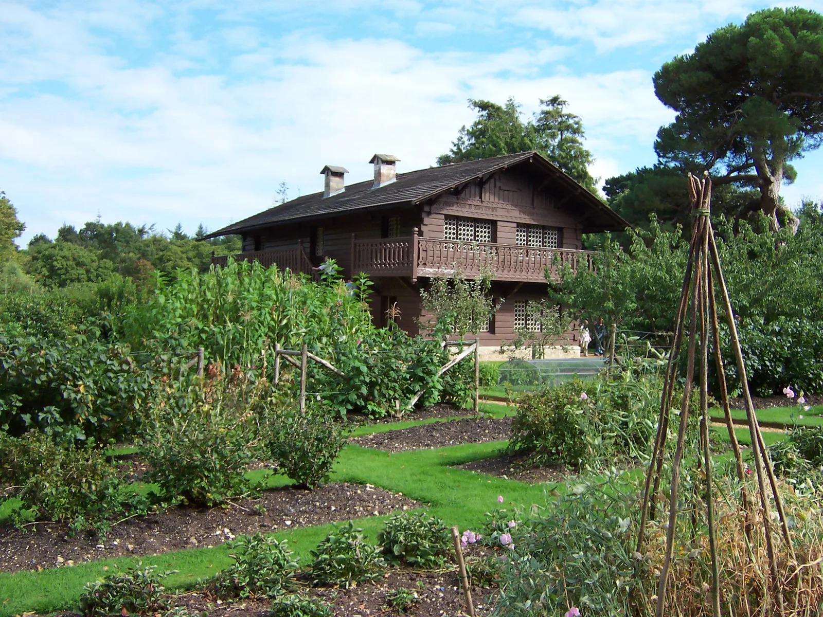 สวนของ Swiss Cottage ใน Osborne House บน Isle of Wight มีแปลงผักและไม้ดอกหน้าบ้านไม้ ภาพถ่ายเดือนกันยายน 2007