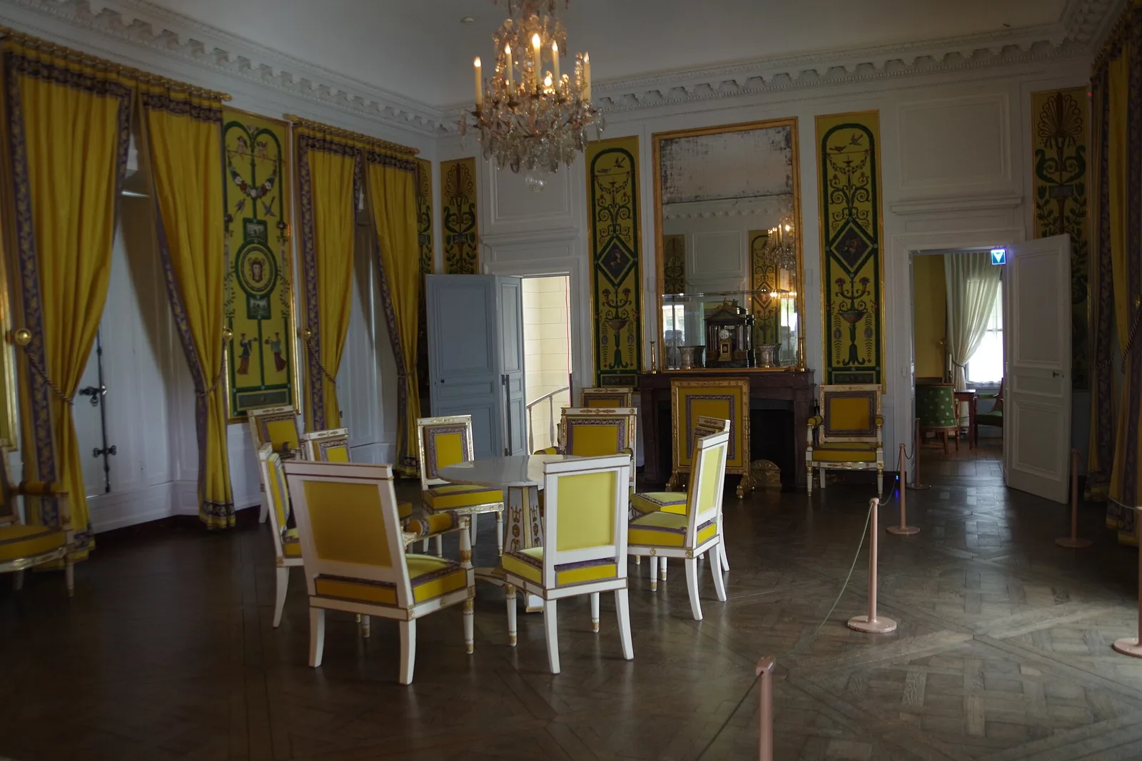 ห้องรับรองใหญ่สีเหลืองชั้นบนของ Maison de la Reine มีม่านและเก้าอี้สีเหลืองกับโคมระย้า