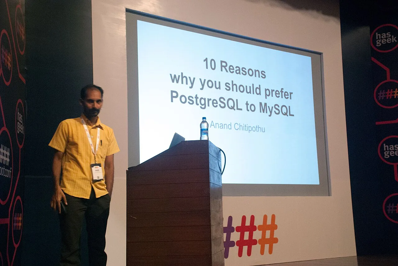 ผู้บรรยายยืนหน้าสไลด์เรื่อง PostgreSQL ในงาน Rootconf 2015