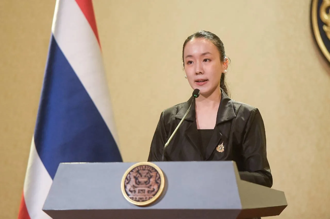 นางสาวลลิดา เพริศวิวัฒนา รองโฆษกประจำสำนักนายกรัฐมนตรี ยืนพูดที่แท่นแถลงข่าวข้างธงชาติไทย ในภาพที่รัฐบาลเผยแพร่ประกอบข่าวการตรวจโรงงานกากอุตสาหกรรมปราจีนบุรี