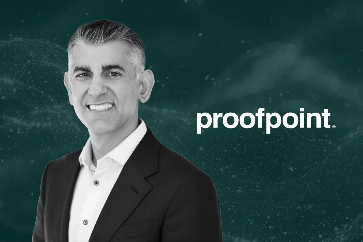 ภาพขาวดำของ Sumit Dhawan ซีอีโอของ Proofpoint ข้างโลโก้ Proofpoint