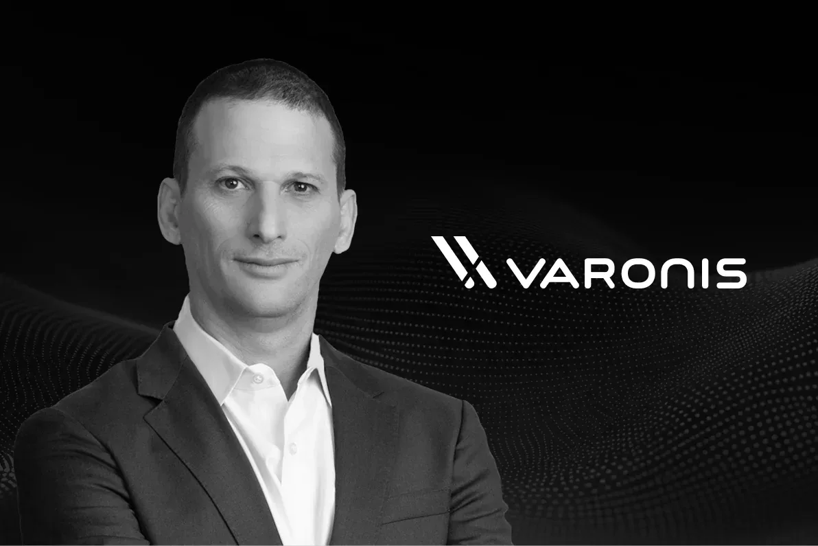 ภาพขาวดำของ Yaki Faitelson ผู้ร่วมก่อตั้งและซีอีโอของ Varonis ข้างโลโก้ Varonis