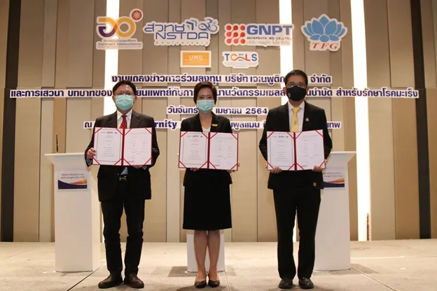 ผู้บริหารสามคนถือเอกสารบนเวทีงานแถลงข่าวการร่วมลงทุนในบริษัท เจเนพูติก ไบโอ จำกัด ของ สวทช. ปี 2564