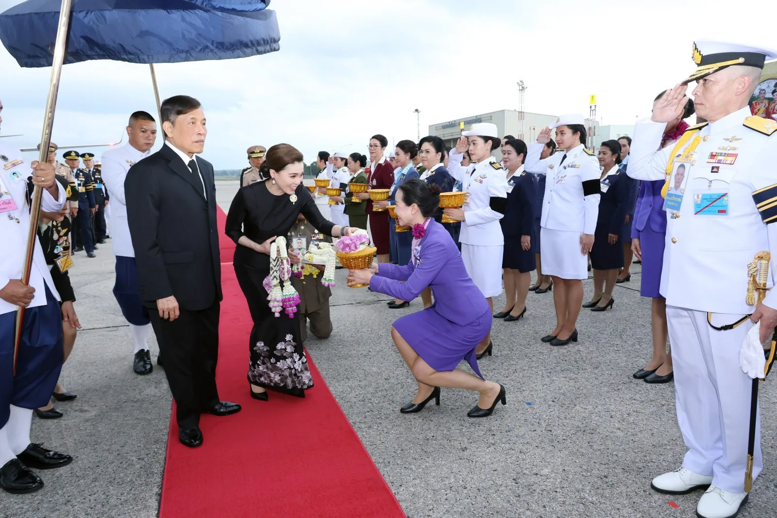 แถวข้าราชการและพานพวงมาลัยบนพรมแดงที่ท่าอากาศยาน