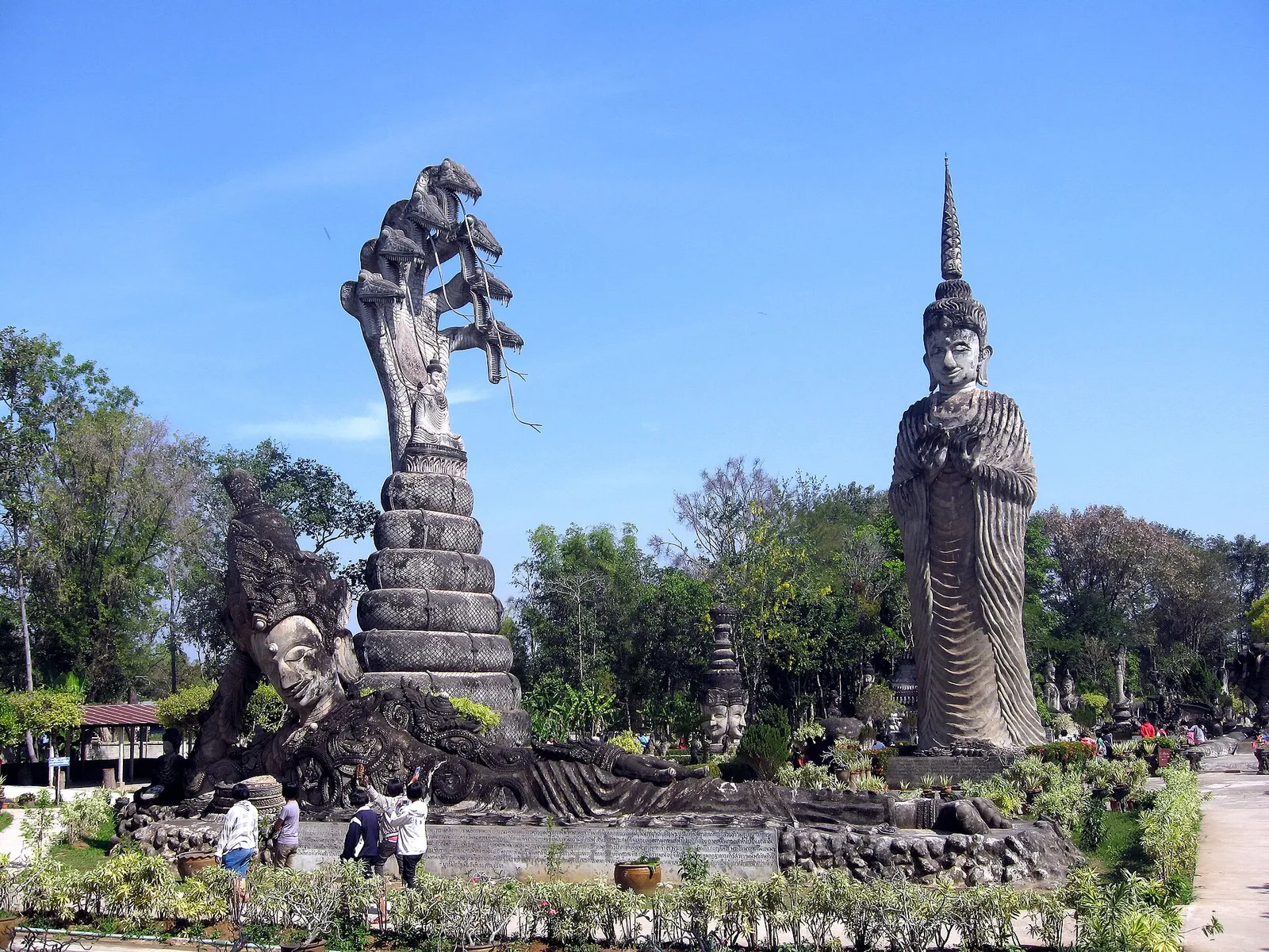 ศาลาแก้วกู่ หนองคาย: รูปปั้นพญานาคหลายเศียรกับรูปปั้นยืนสูงในสวนใต้ท้องฟ้าสีคราม ภาพถ่ายเดือนมกราคม 2010