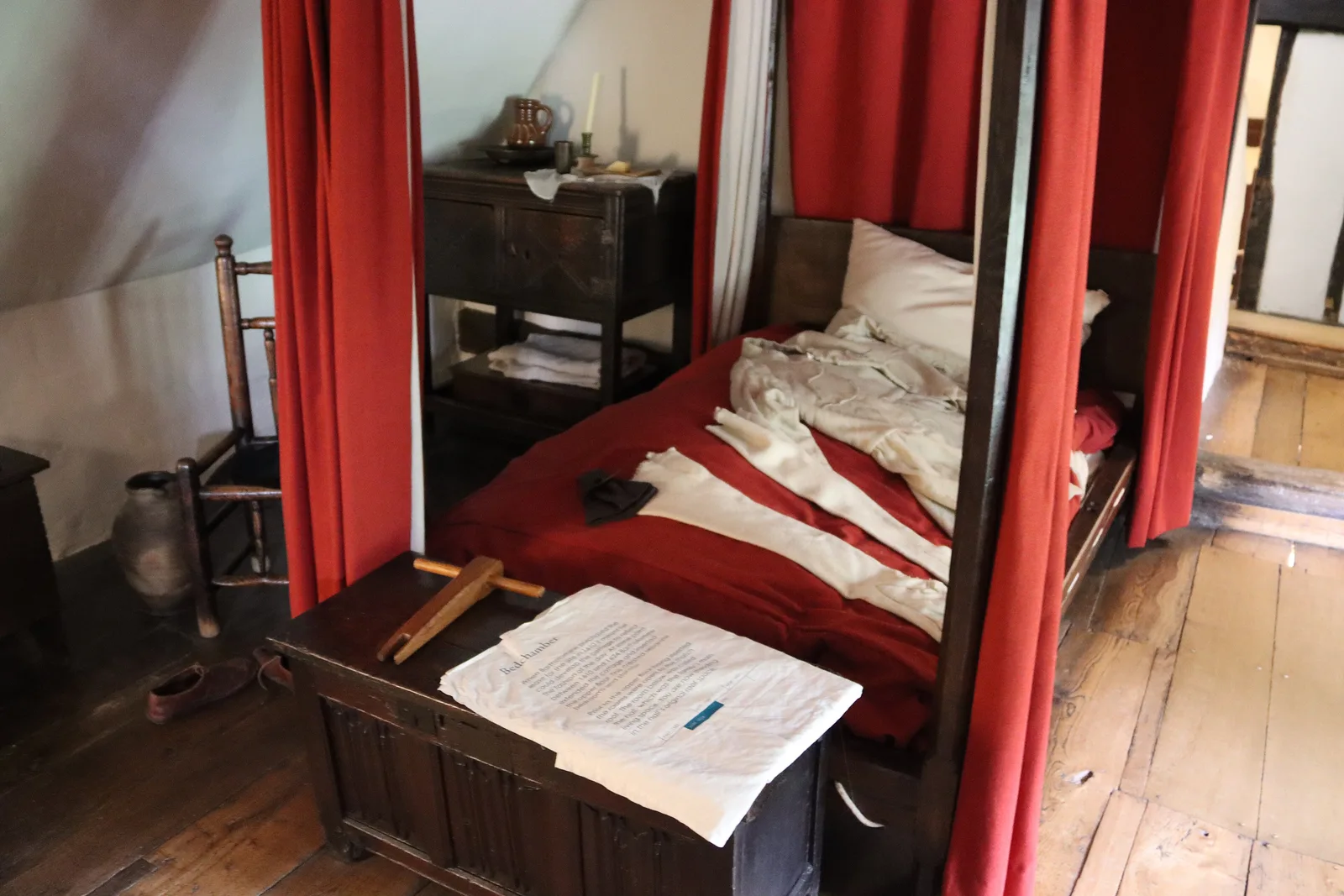 ห้องนอนที่มีเตียงม่านสีแดงภายใน Anne Hathaway's Cottage ภาพถ่ายเมื่อ 7 สิงหาคม 2024