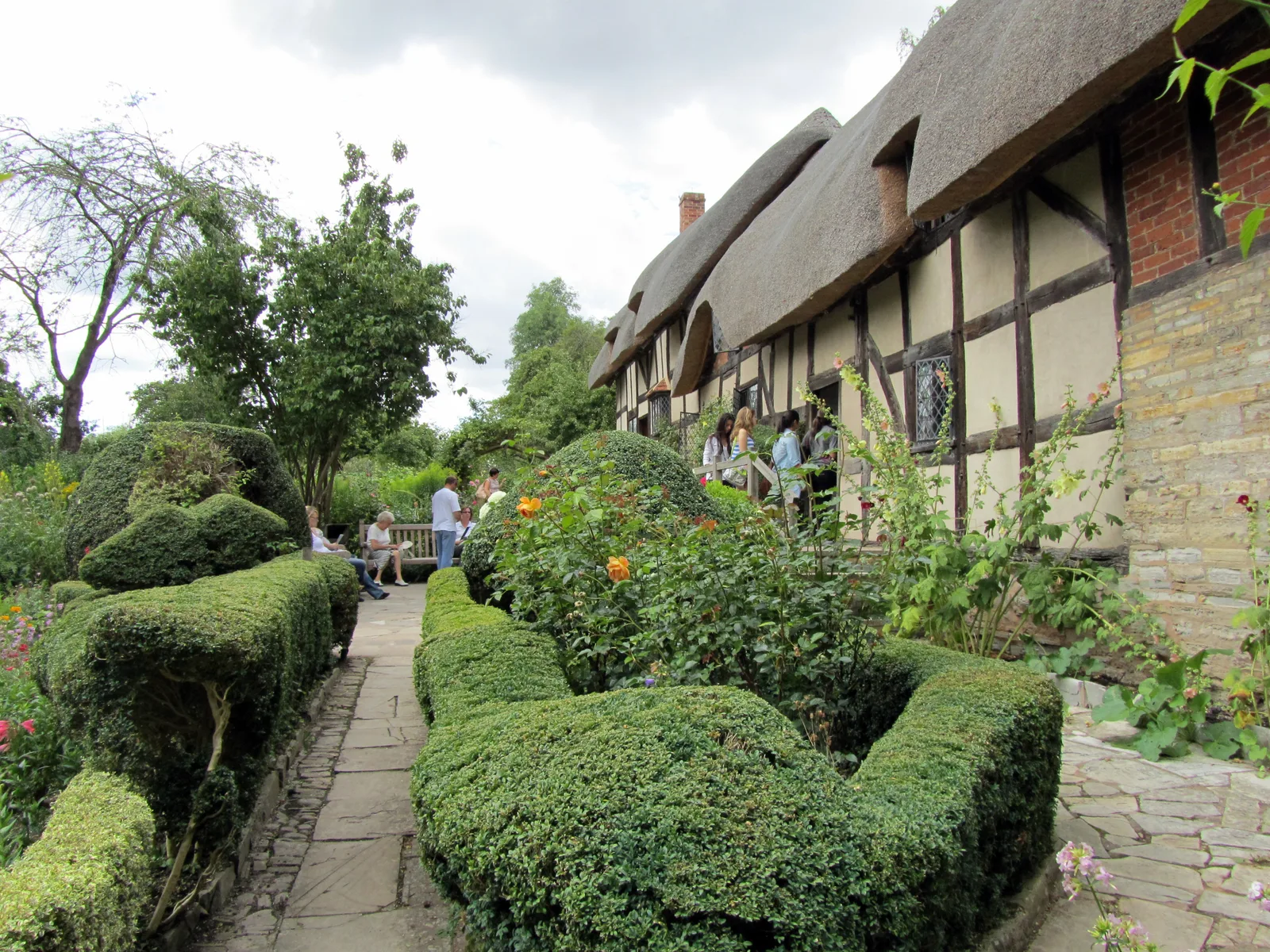 ทางเดินระหว่างพุ่มไม้ตัดแต่งข้าง Anne Hathaway's Cottage ภาพถ่ายเมื่อ 25 กรกฎาคม 2010