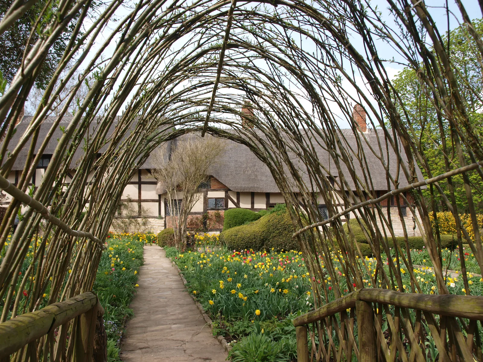 อุโมงค์กิ่งไม้สานเหนือทางเดินในสวนของ Anne Hathaway's Cottage ภาพถ่ายเมื่อ 14 เมษายน 2012