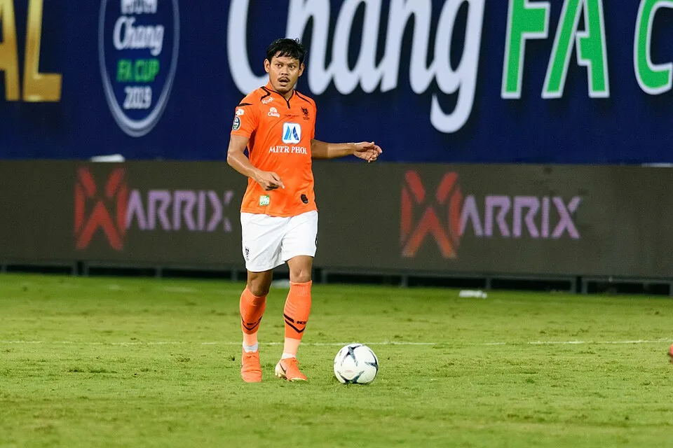 Alongkorn Prathumwong ในชุดแข่งสีส้ม กางเกงขาว ถุงเท้าส้มของราชบุรี คุมบอลในเกมนัดชิงเอฟเอ คัพ ปี 2019 กับการท่าเรือ