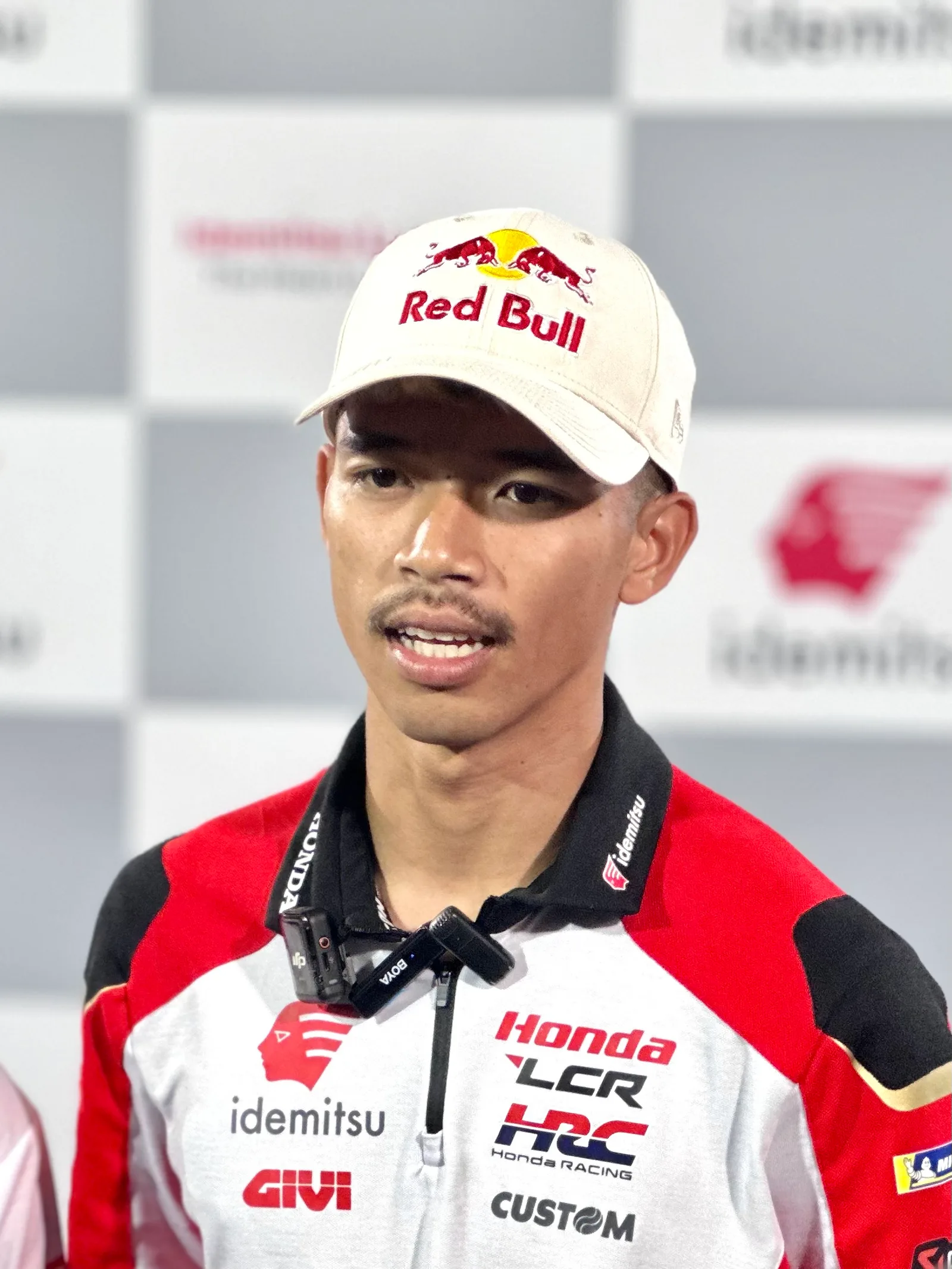 สมเกียรติ จันทรา สวมหมวกแก๊ปและเสื้อทีม Honda LCR ให้สัมภาษณ์ในงานแถลงข่าวของทีม Idemitsu LCR Honda ก่อน MotoGP 2025 ที่บุรีรัมย์